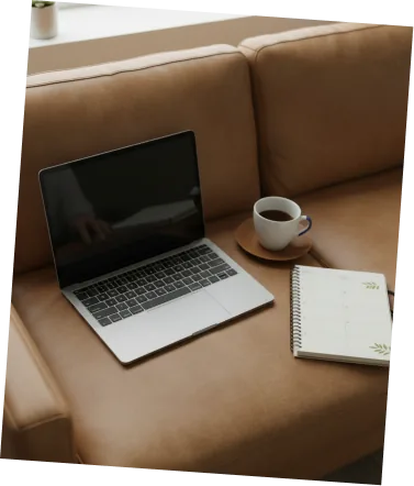 Laptop, coffee, and notebook styled on a couch